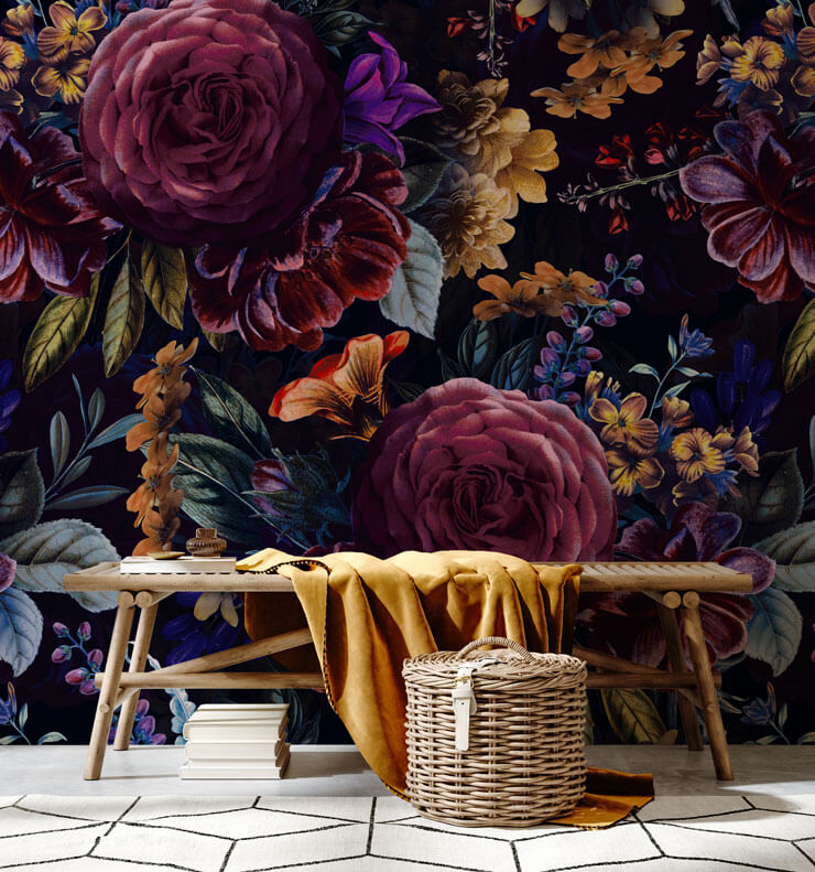 Dark floral wallpaper with pink and purple flowers and a wooden bench and muted gold throw