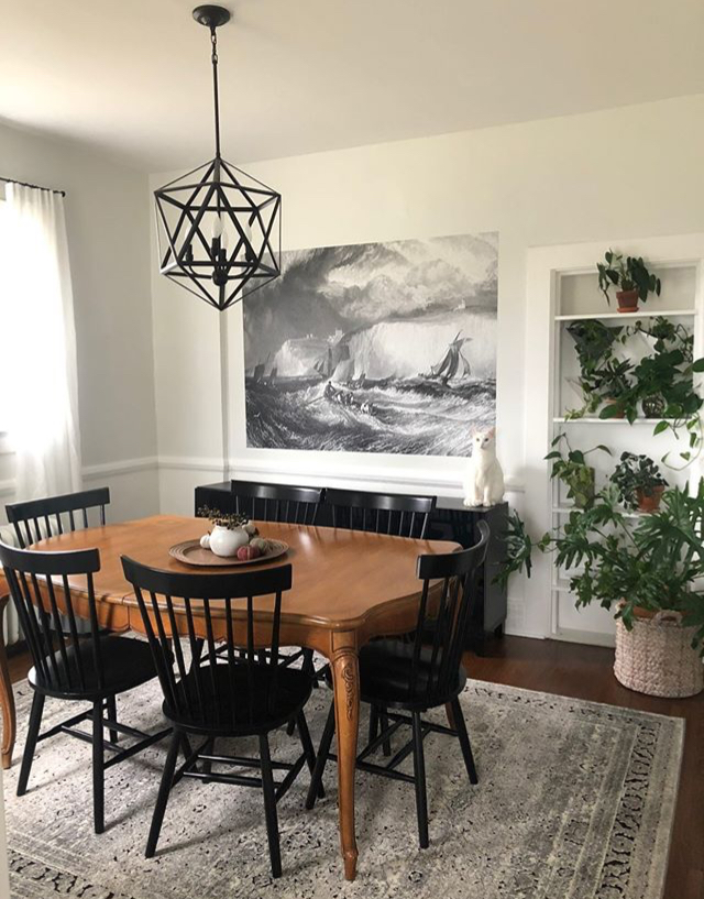 black and white painting of stormy sea with ship in minimalist trendy dining room
