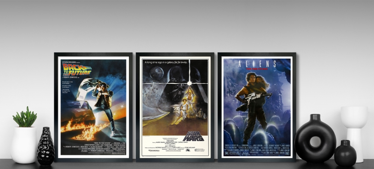 trio of movie posters on a shelf